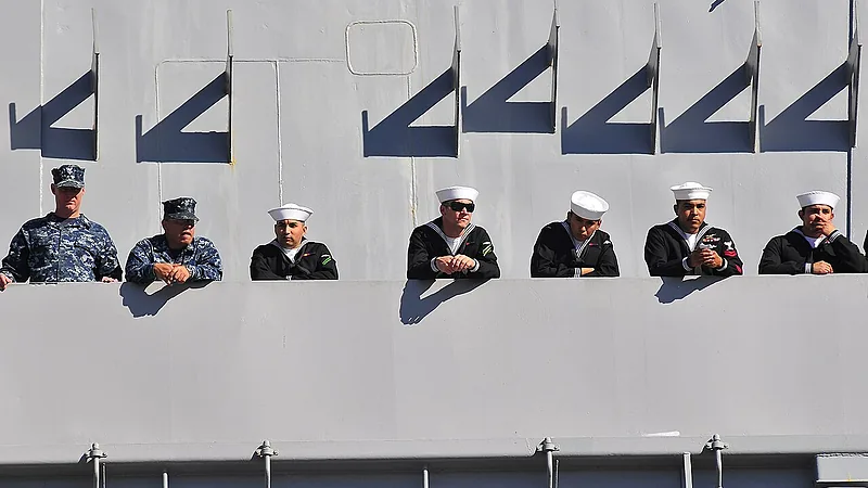 US Navy 101130-N-5528G-175 Sailors assigned to the aircraft carrier USS Carl Vinson (CVN 70) watch family members on the pier from the ship's catwa